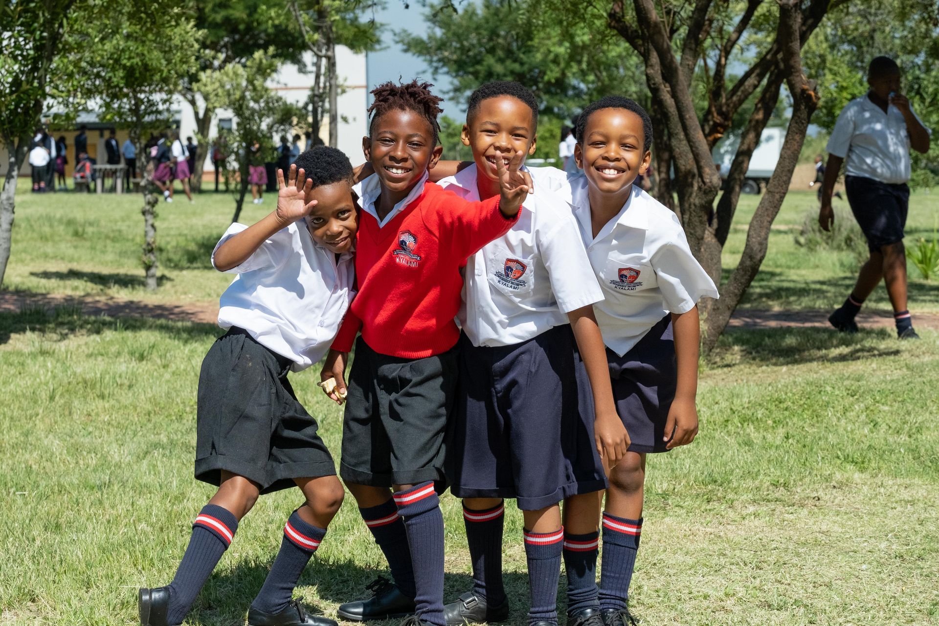 A group of young boys are posing for a picture in a park.