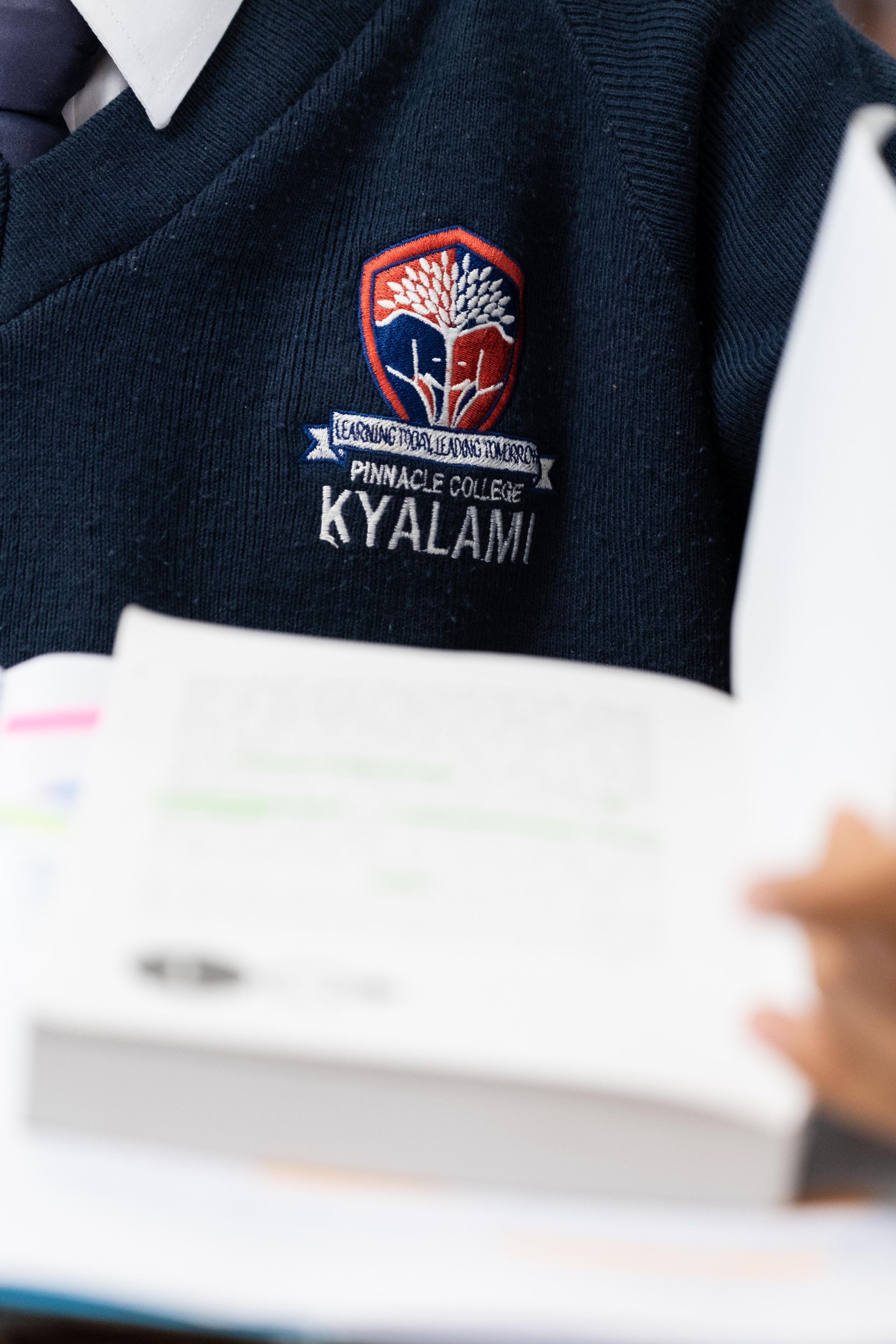 A person wearing a blue sweater with the word kyalam on it.