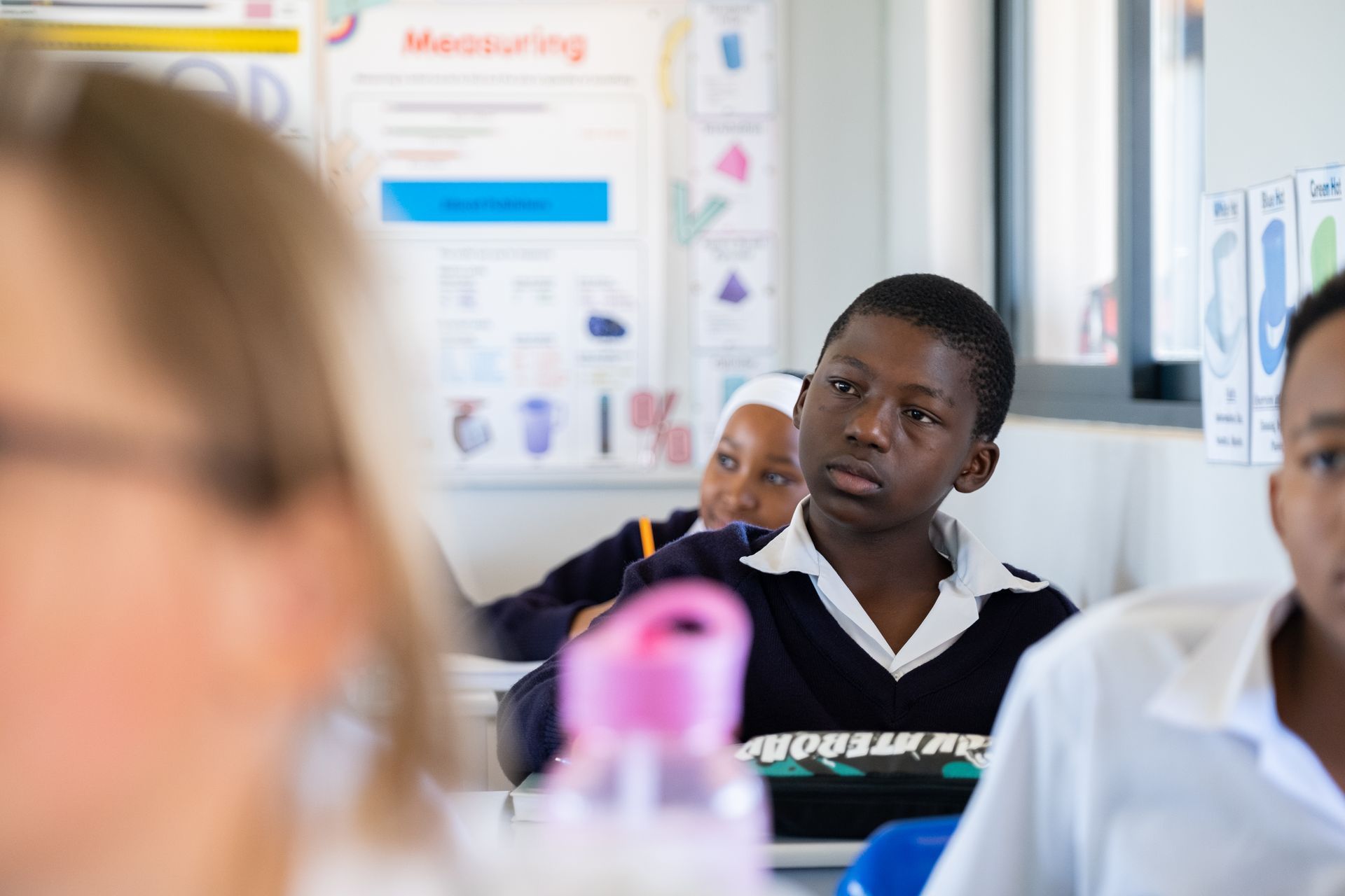 A group of children are sitting at their desks in a classroom.