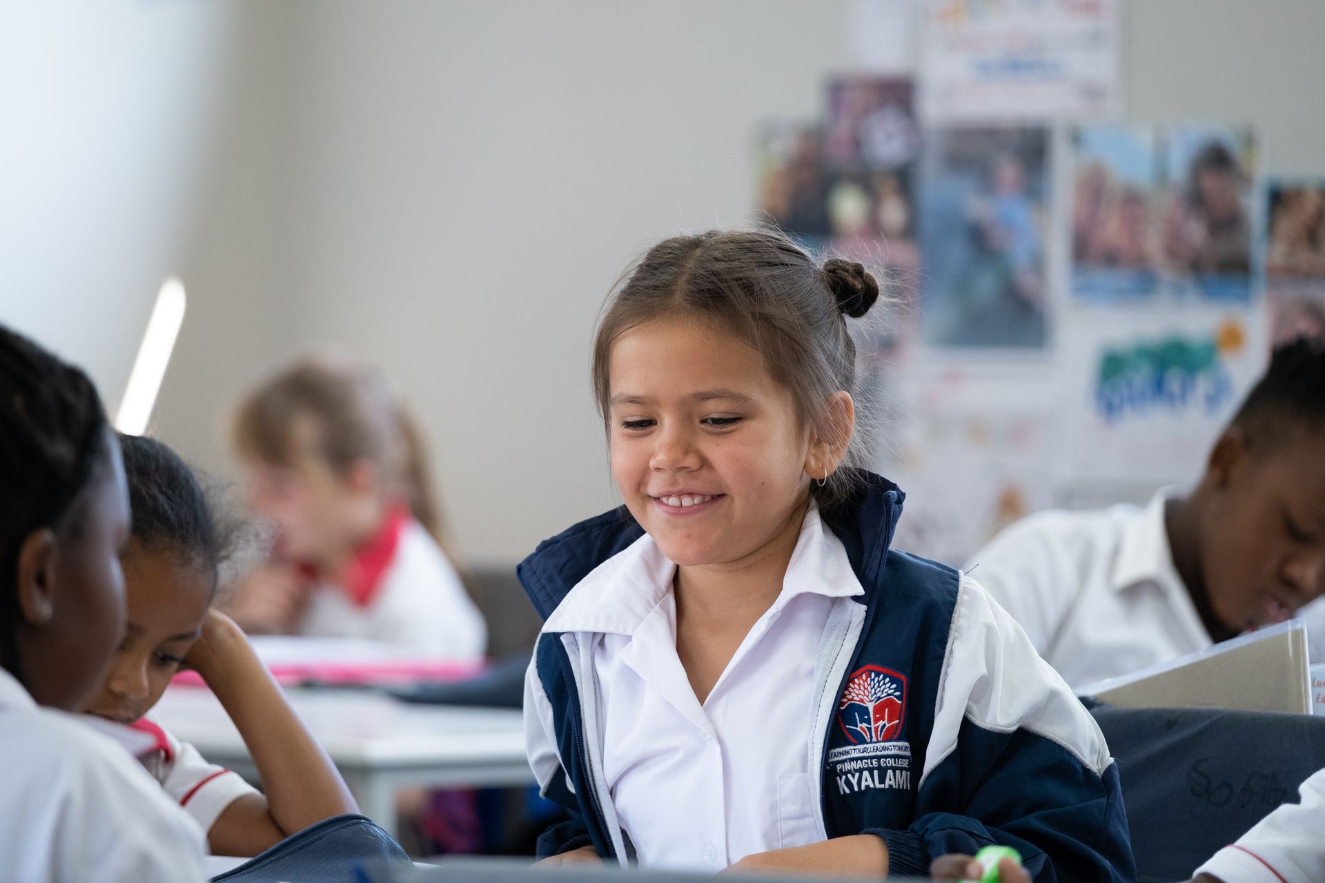 A group of children are sitting at desks in a classroom.