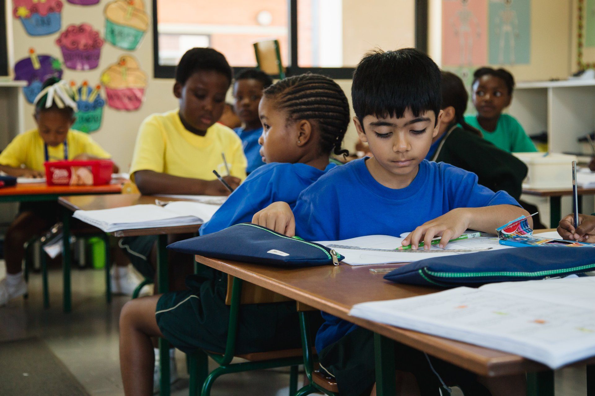 A group of children are sitting at desks in a classroom.