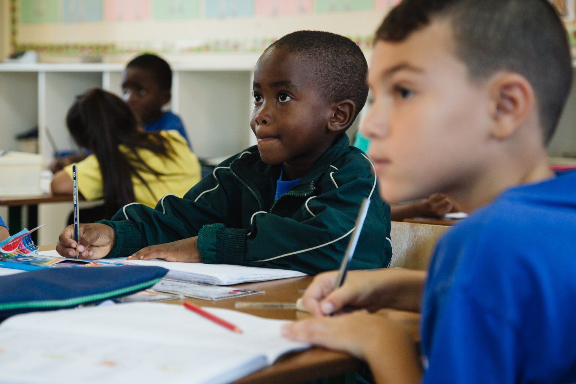 A group of children are sitting at their desks in a classroom.