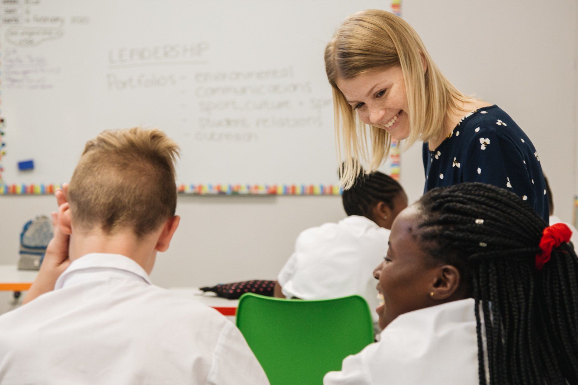 A teacher is talking to a student in a classroom.