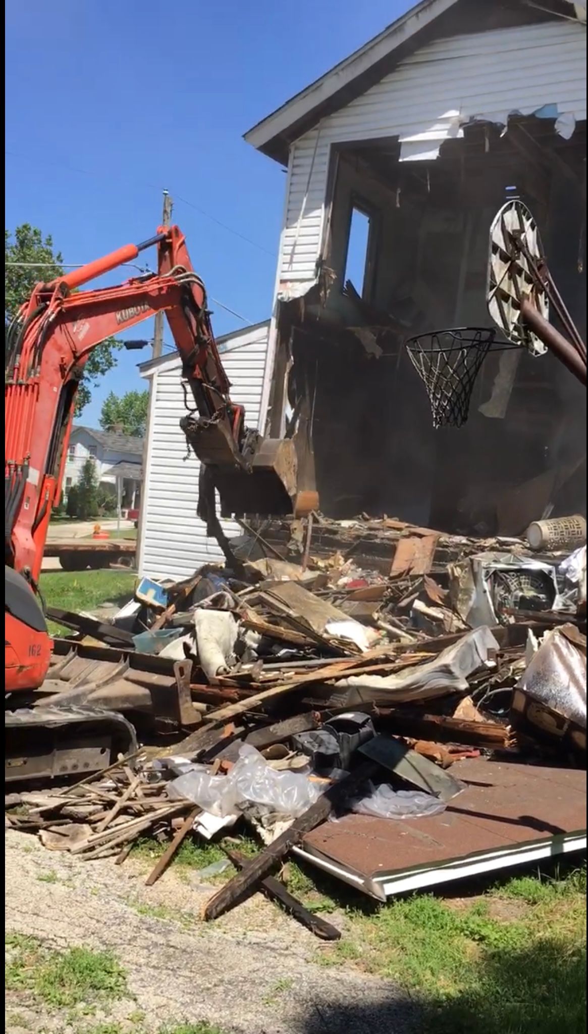 A construction worker is using a hammer to demolish a wall.
