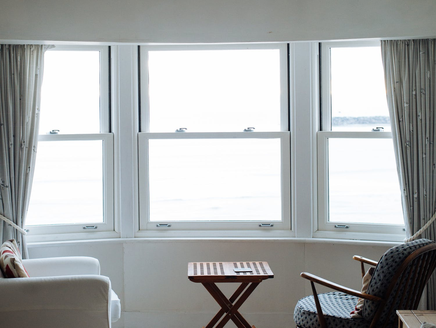 A living room with two chairs and a table in front of a window.