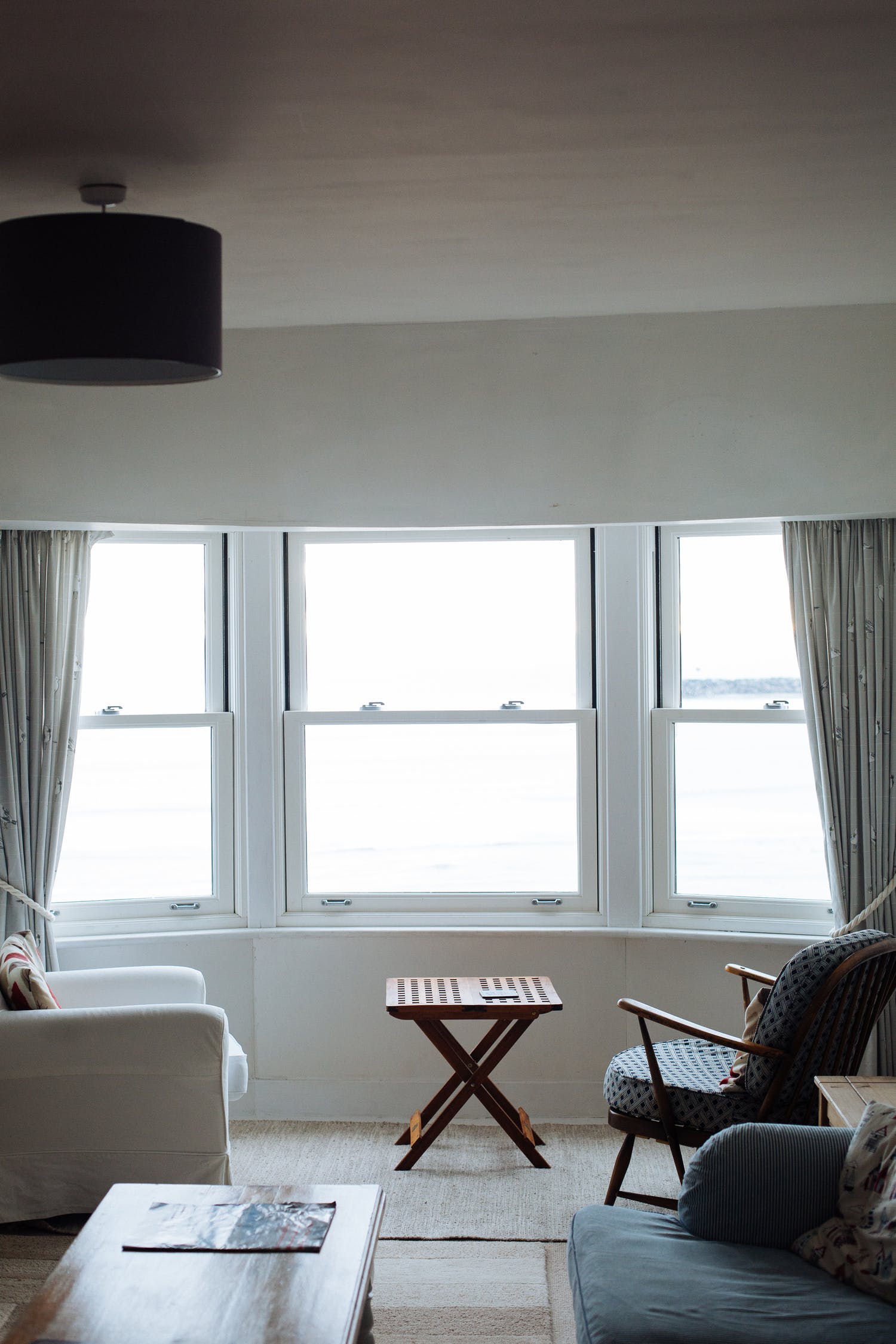 A living room with a couch , chair , table and window.