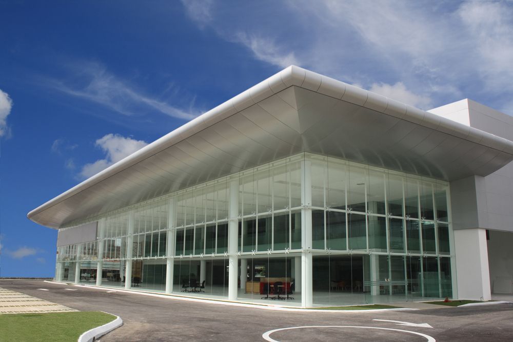 A Large Building with A Lot of Windows and A Car Parked in Front of It — Thomas Croker Constructions In Myrtleville, NSW