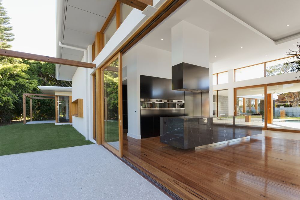 An empty house with a kitchen and sliding glass doors — Thomas Croker Constructions In Myrtleville, NSW