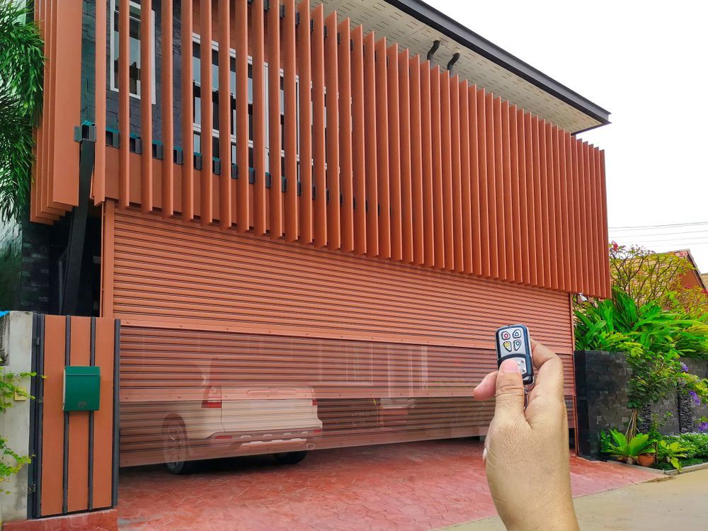 A Person Is Holding a Remote Control in Front of A Garage Door — Thomas Croker Constructions In Myrtleville, NSW