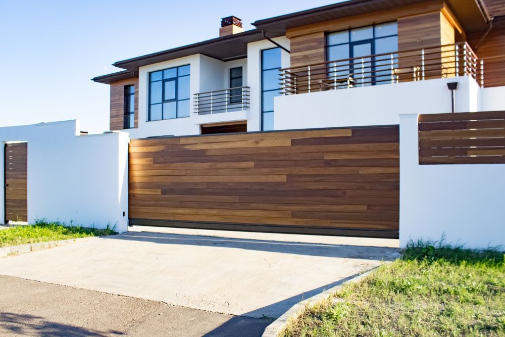 A Large House with A Wooden Fence and Sliding Garage Door — Thomas Croker Constructions In Myrtleville, NSW