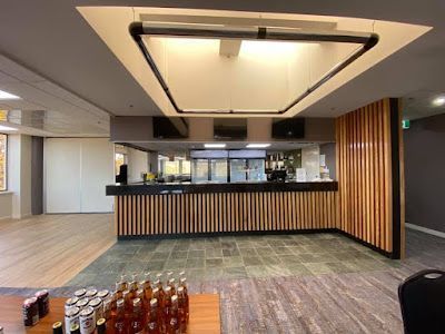 A large room with a wooden counter and bottles on a table. — Thomas Croker Constructions In Myrtleville, NSW
