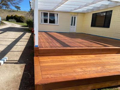 A Wooden Deck Is Sitting in Front of A Yellow House — Thomas Croker Constructions In Myrtleville, NSW