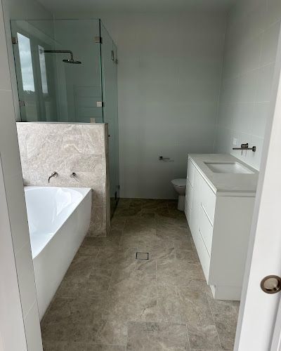 A bathroom with a bathtub , sink , toilet and shower. — Thomas Croker Constructions In Myrtleville, NSW