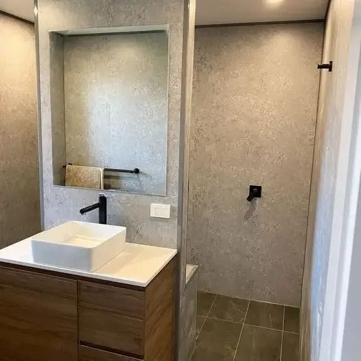 A bathroom with a sink , mirror and shower. — Thomas Croker Constructions In Myrtleville, NSW