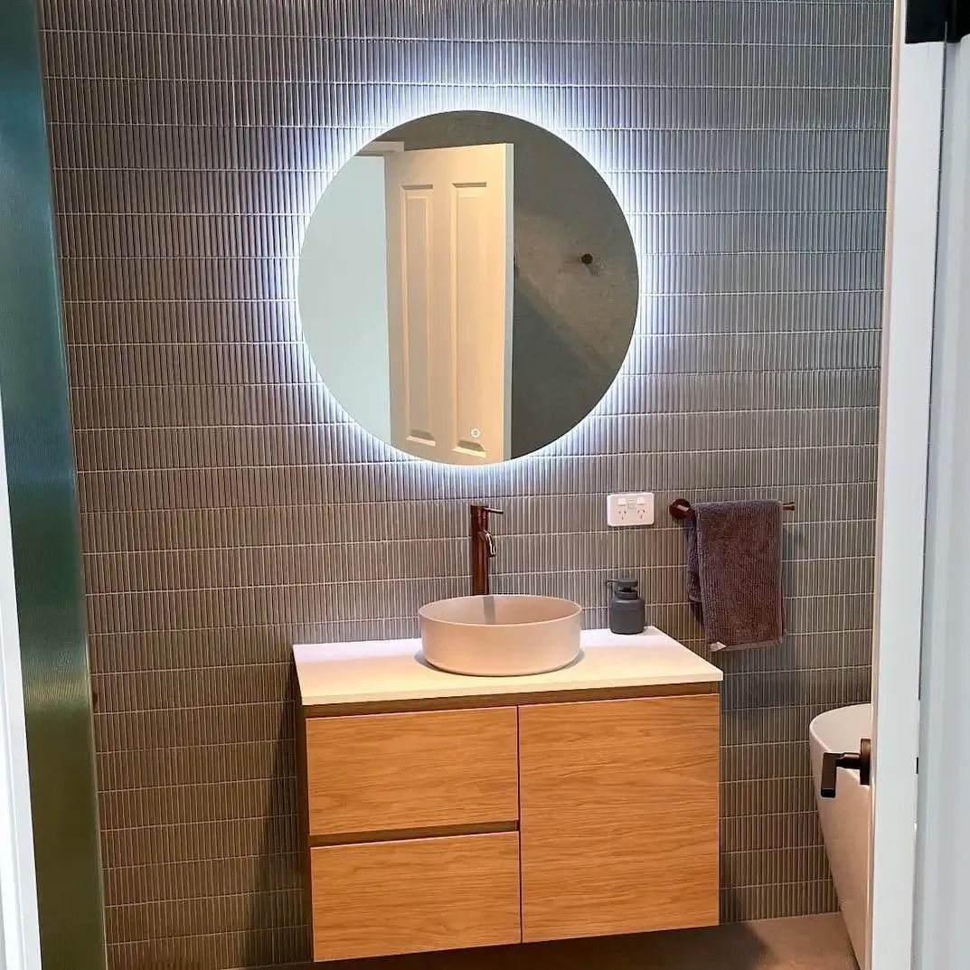 A bathroom with a sink , mirror and toilet. — Thomas Croker Constructions In Myrtleville, NSW