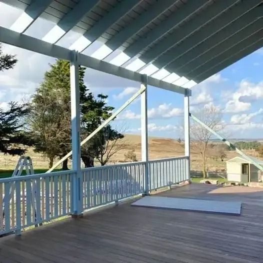 A Wooden Deck with A White Railing and A View of A Field — Thomas Croker Constructions In Myrtleville, NSW