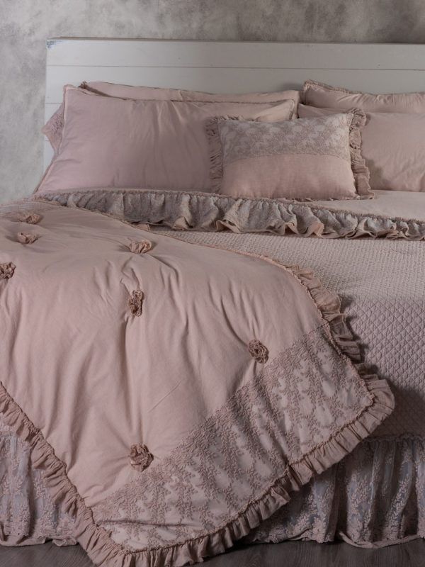 Letto rosa con lenzuola in pizzo e volant, con coperta coordinata.