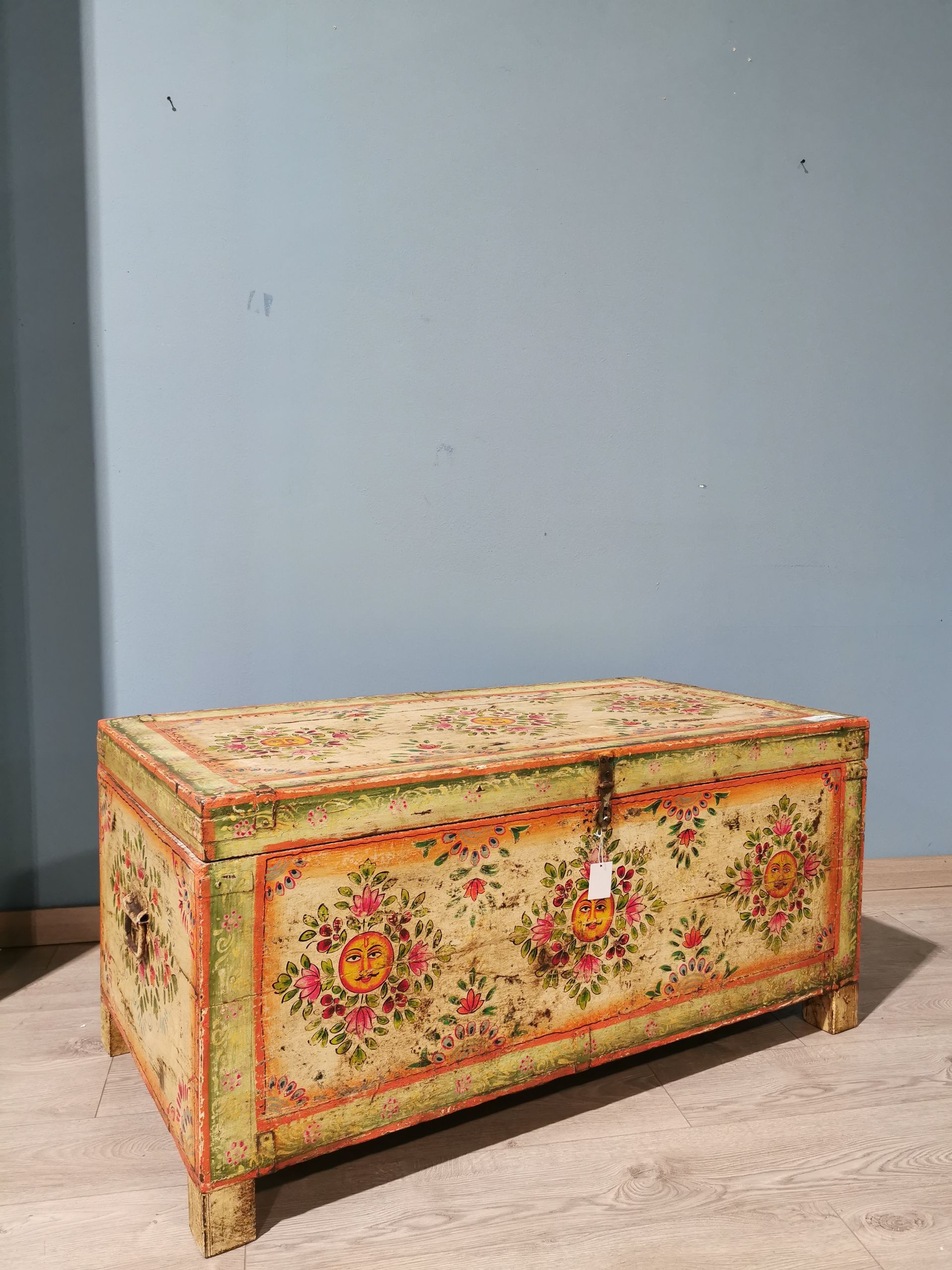 Letto con lenzuola bianche, bordi in pizzo e cuscini decorativi di fronte a grandi finestre.