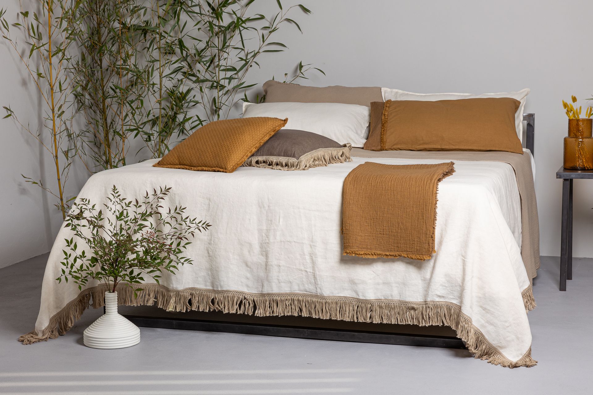 Due asciugamani verde oliva con frange testurizzate, piegati su una superficie di legno.