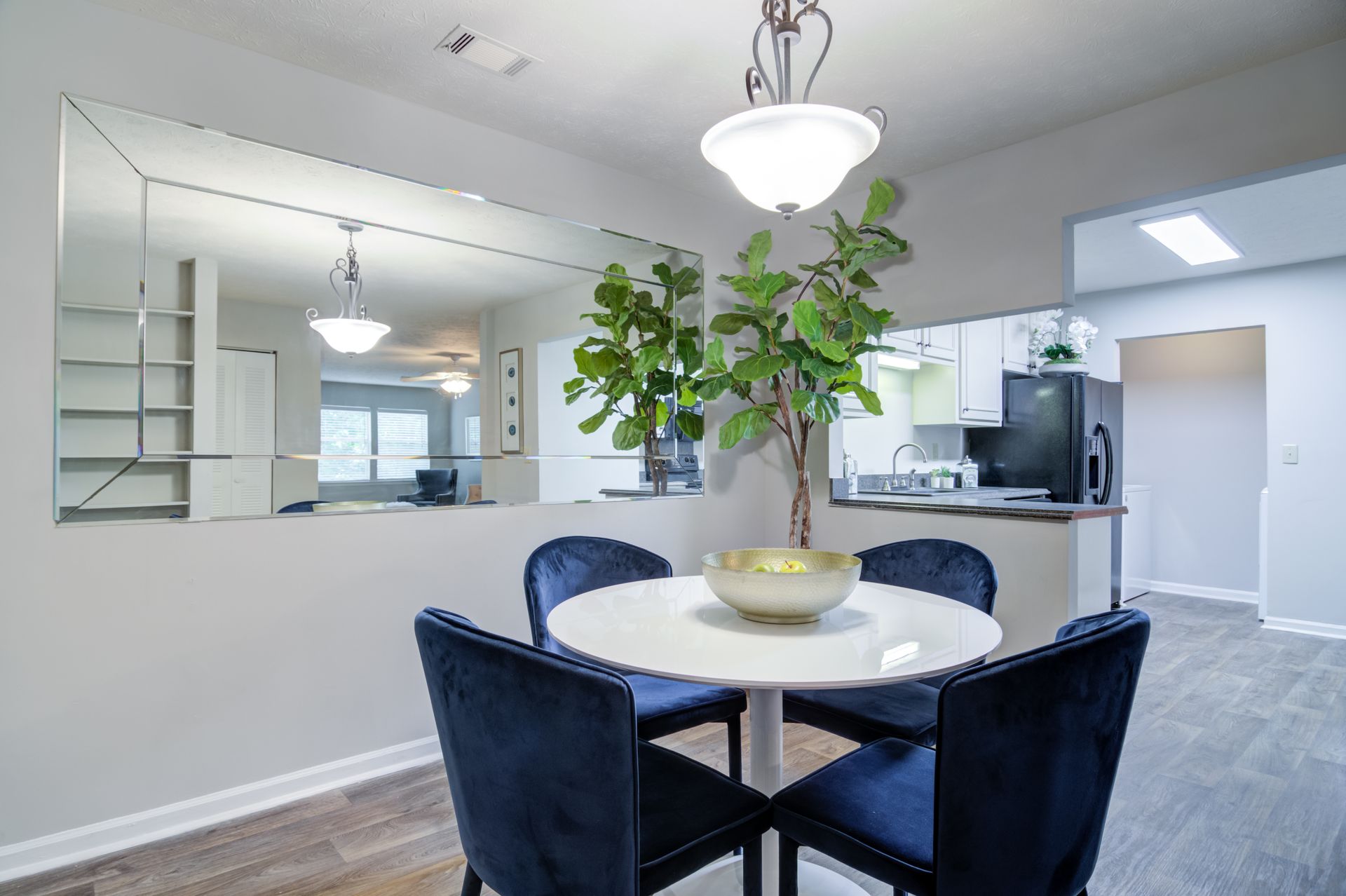 A dining room with a round table and blue chairs.