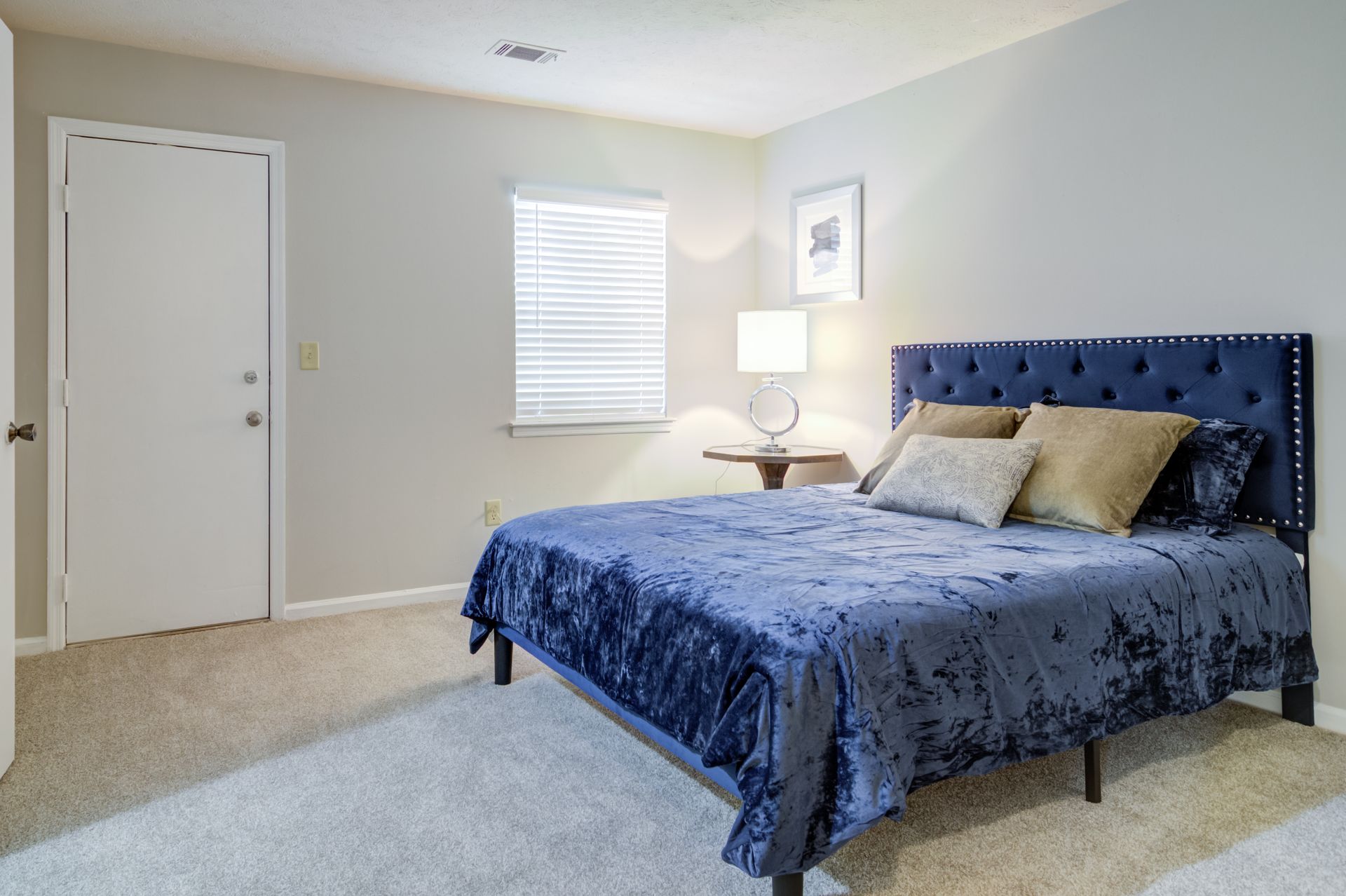 A kitchen with white cabinets , a black refrigerator , and a fireplace.