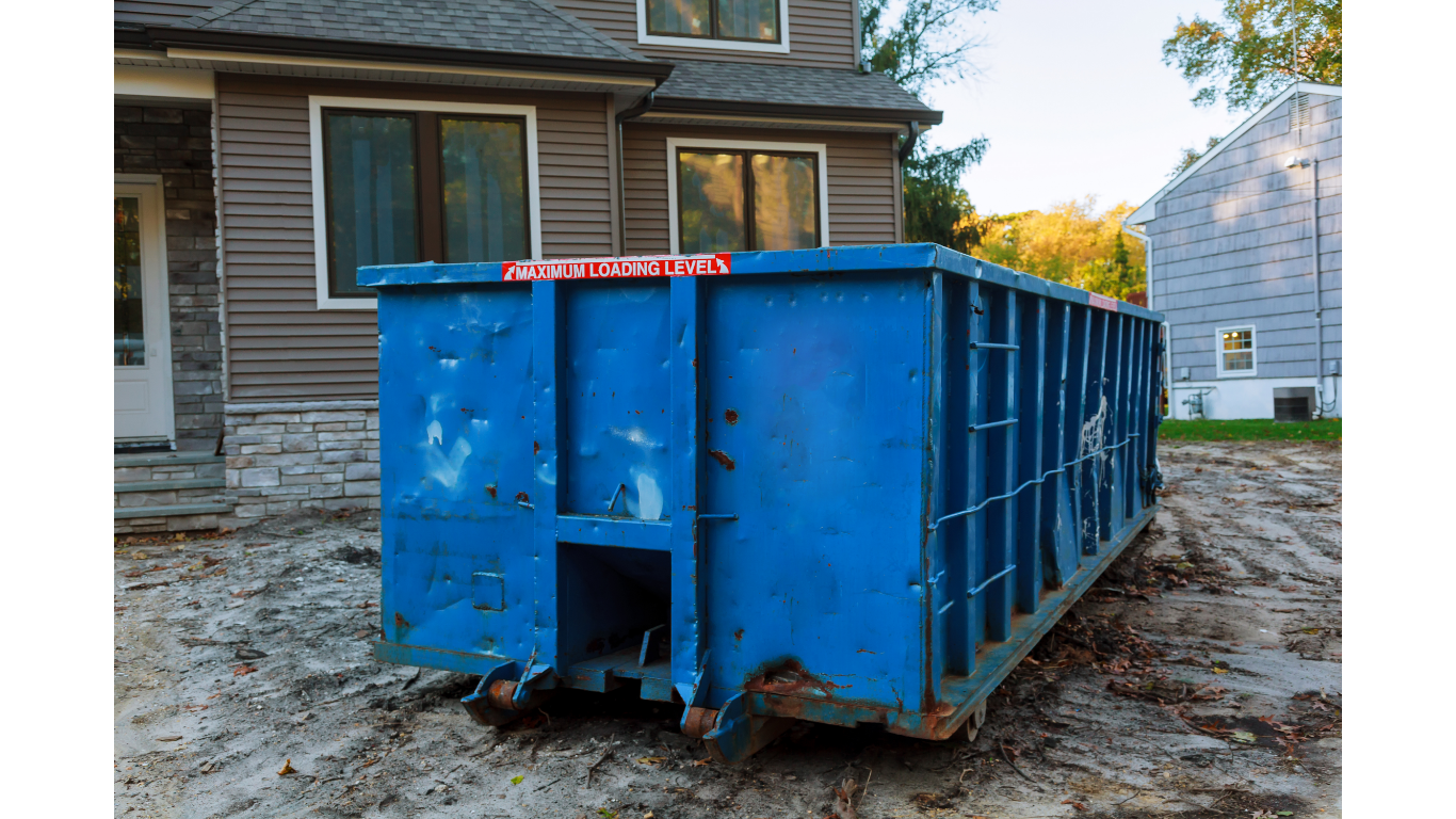 Blue dumpster in front of a house, likely for construction or renovation debris.
