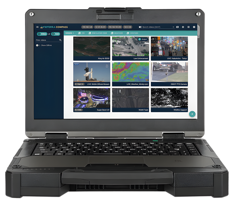 Rugged laptop displaying a grid of surveillance camera feeds, likely monitoring various locations.