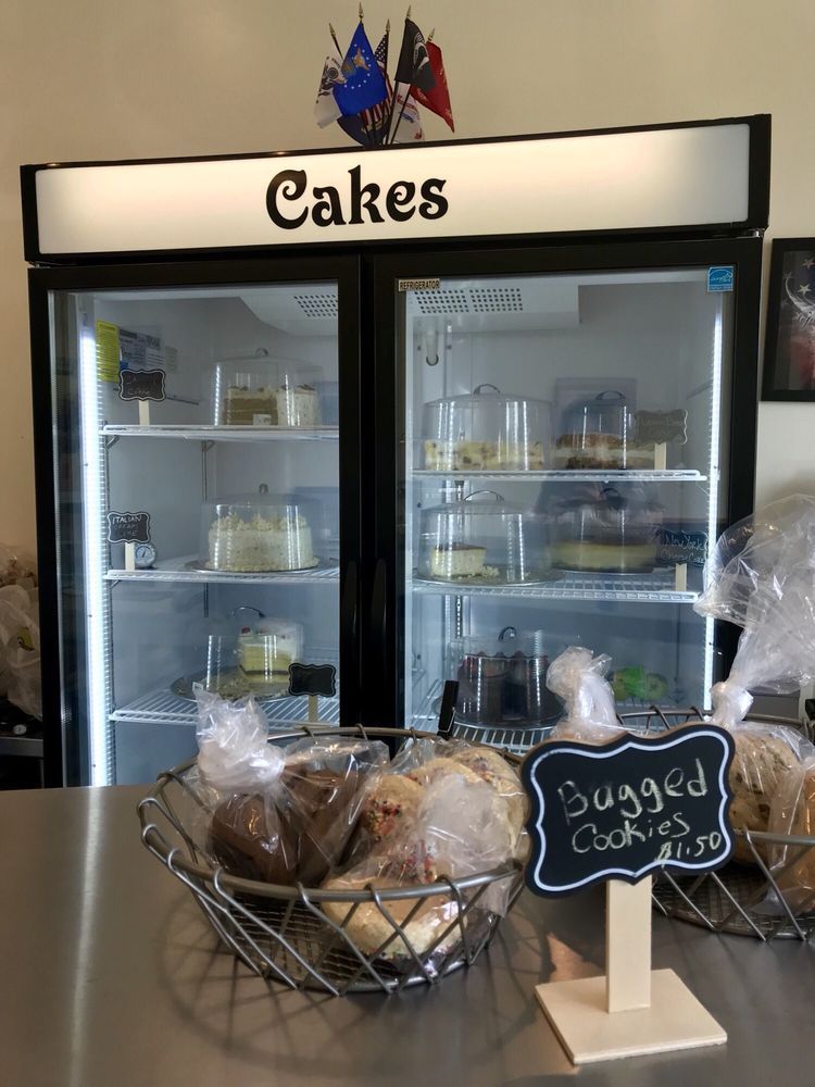 A display of cakes and cookies in a refrigerator
