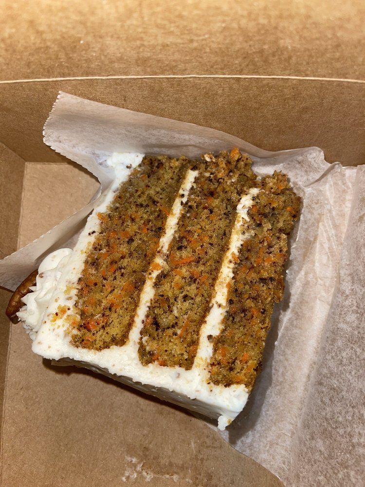 A close up of a slice of carrot cake in a box