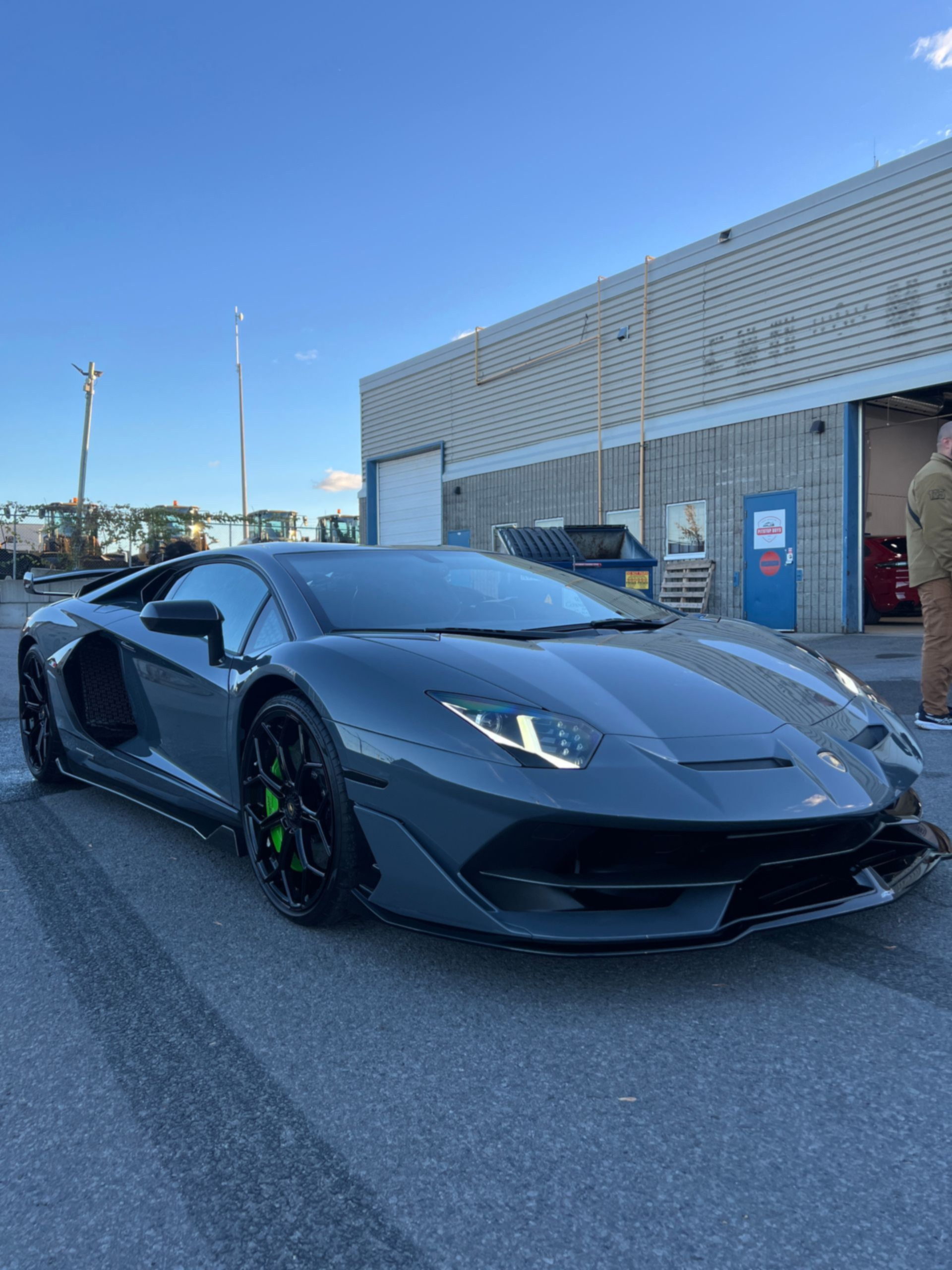 Black sports car parked outside a building on a sunny day