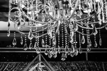 Crystal chandelier hanging in a room, reflecting light and creating sparkles.