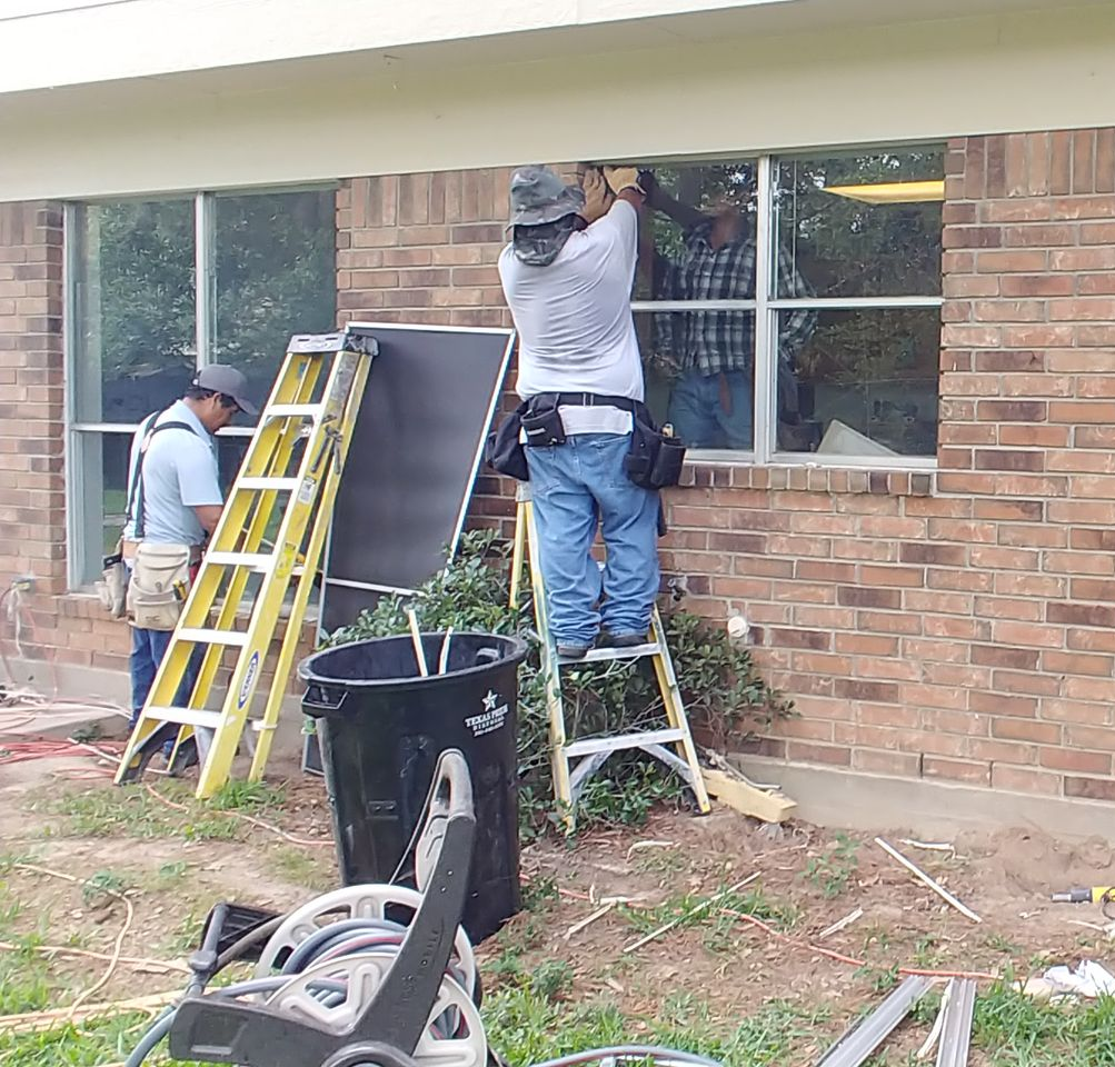 Person opening a wooden-framed screen on a skylight in a wood-paneled ceiling. Person installing a wooden framed screen in a skylight.