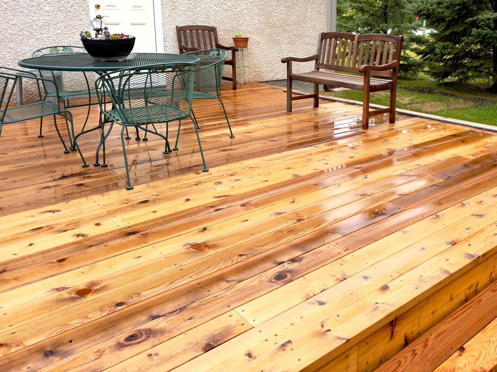 Person measuring and cutting brown composite decking with gloves, square, and tape. Person wearing white gloves measures and works on a brown deck with a ruler.