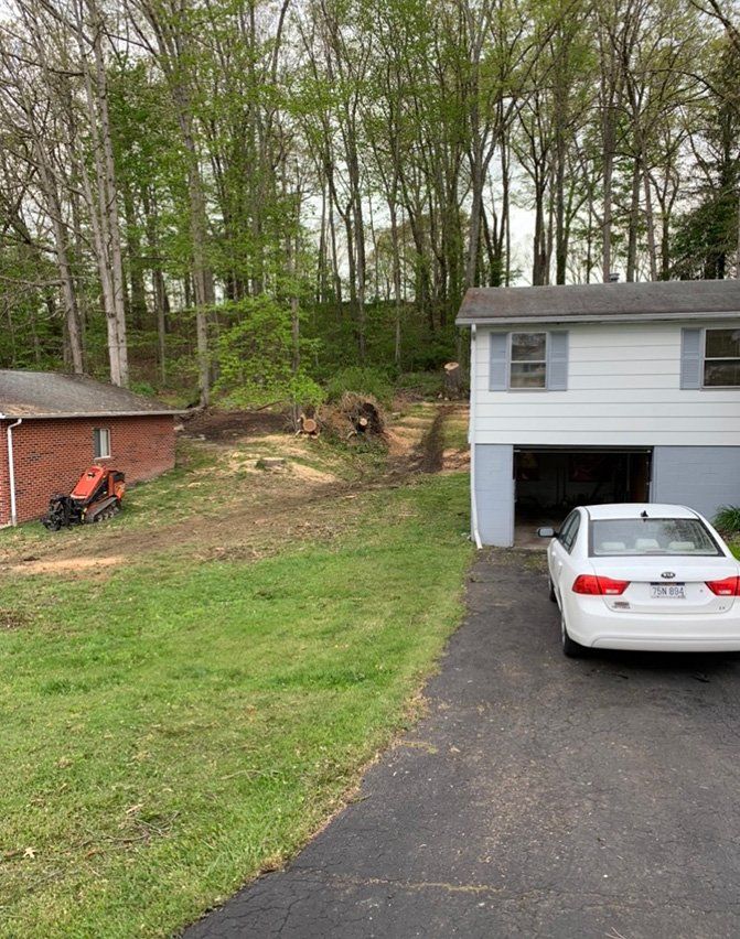 White car parked in front of small white house — Daniels, WV — Mastiff Lawn & Tree Care