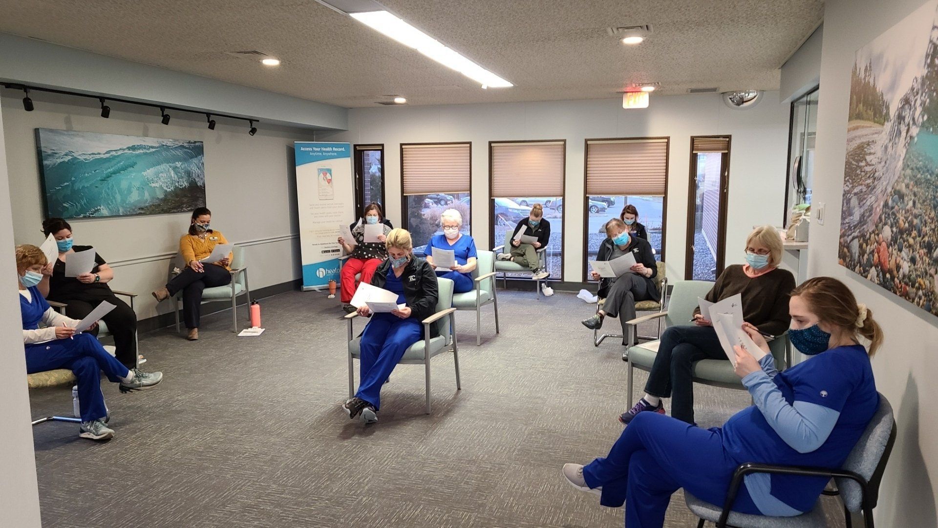 A group of people are sitting in chairs in a waiting room.