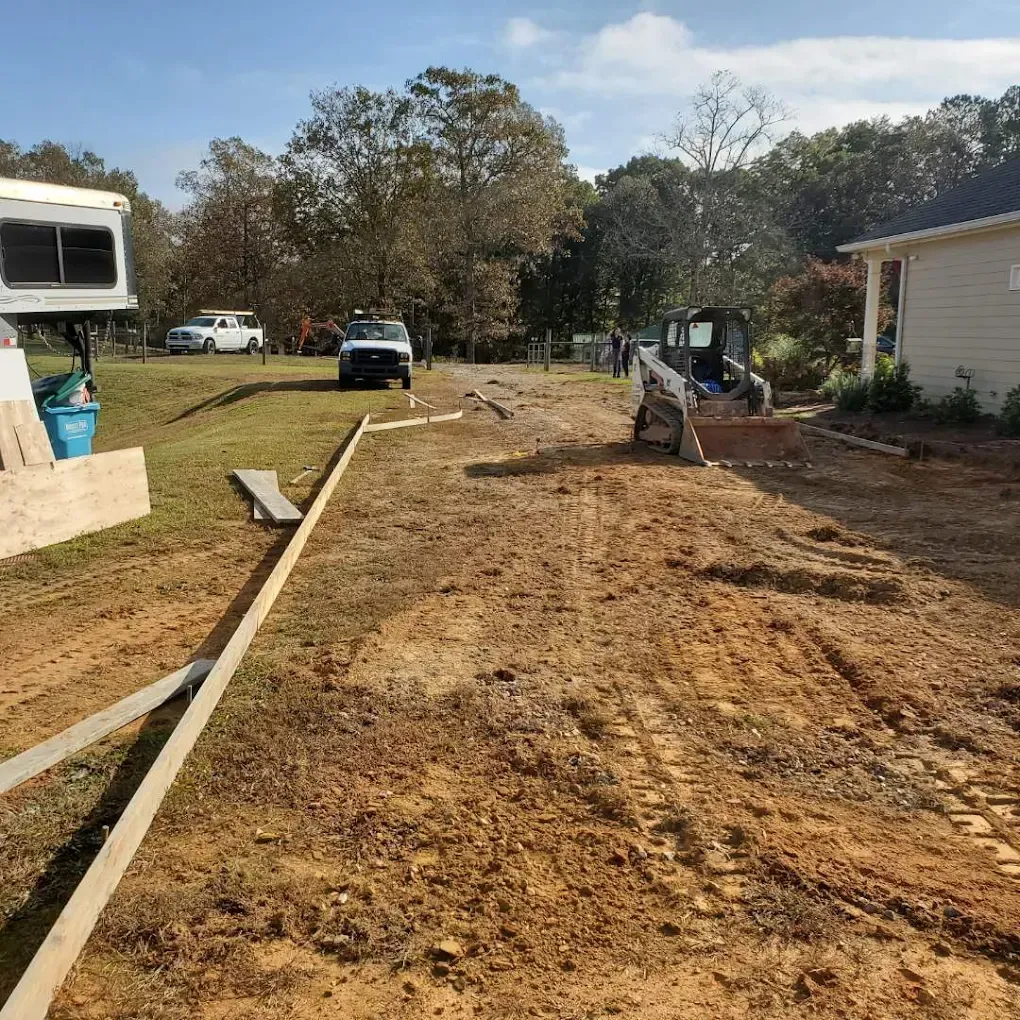 Dirt driveway under construction, with a small tractor.