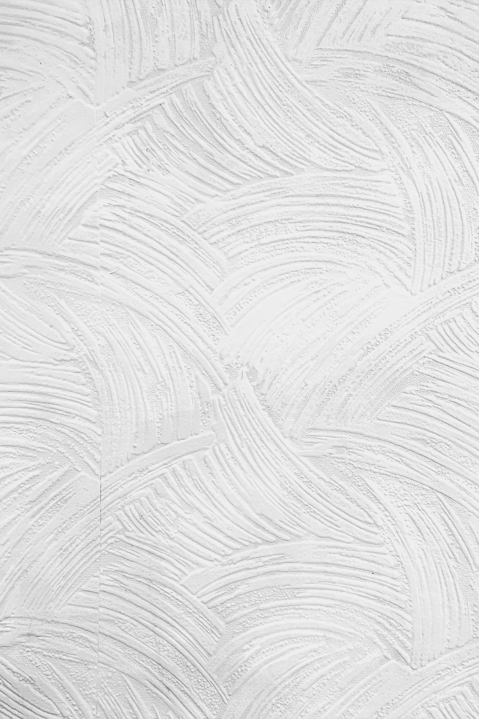 White wall with textured, curved brushstrokes.