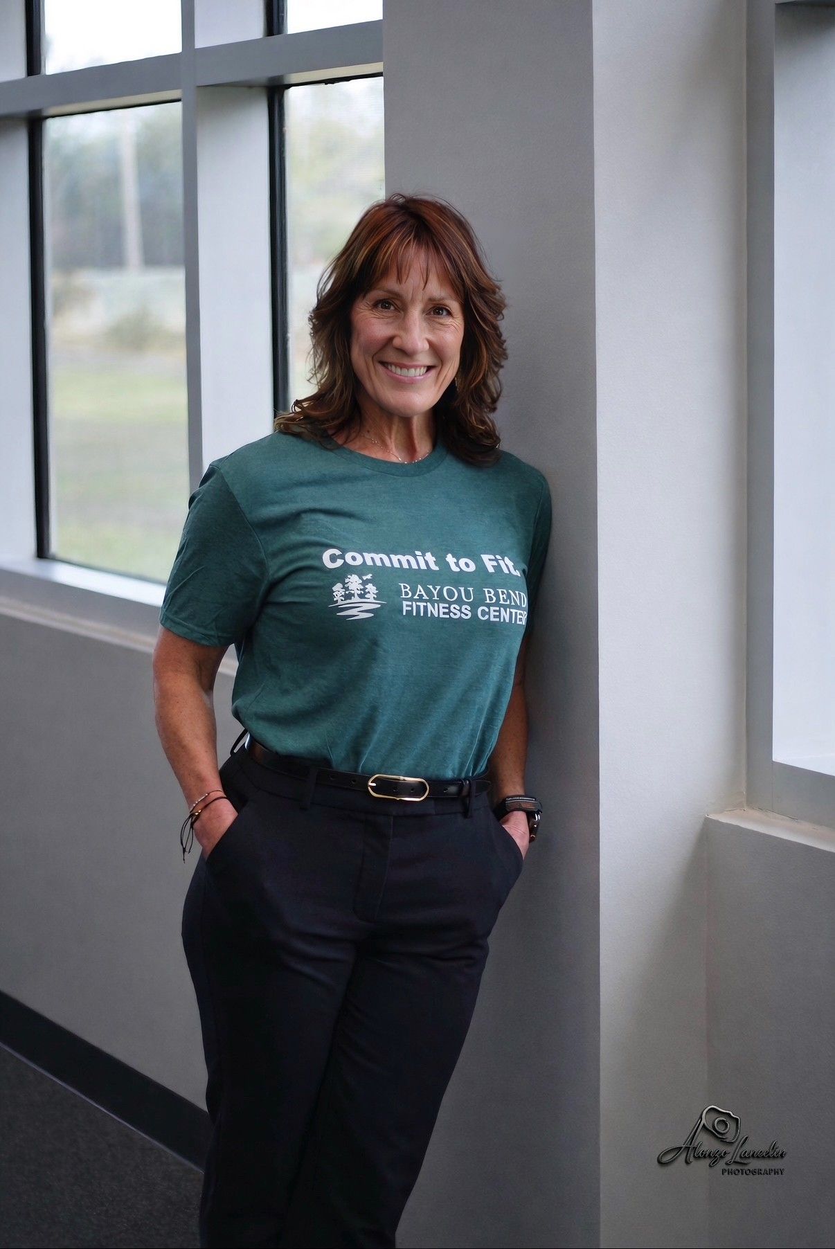 A woman is standing in a hallway with her hands on her hips.