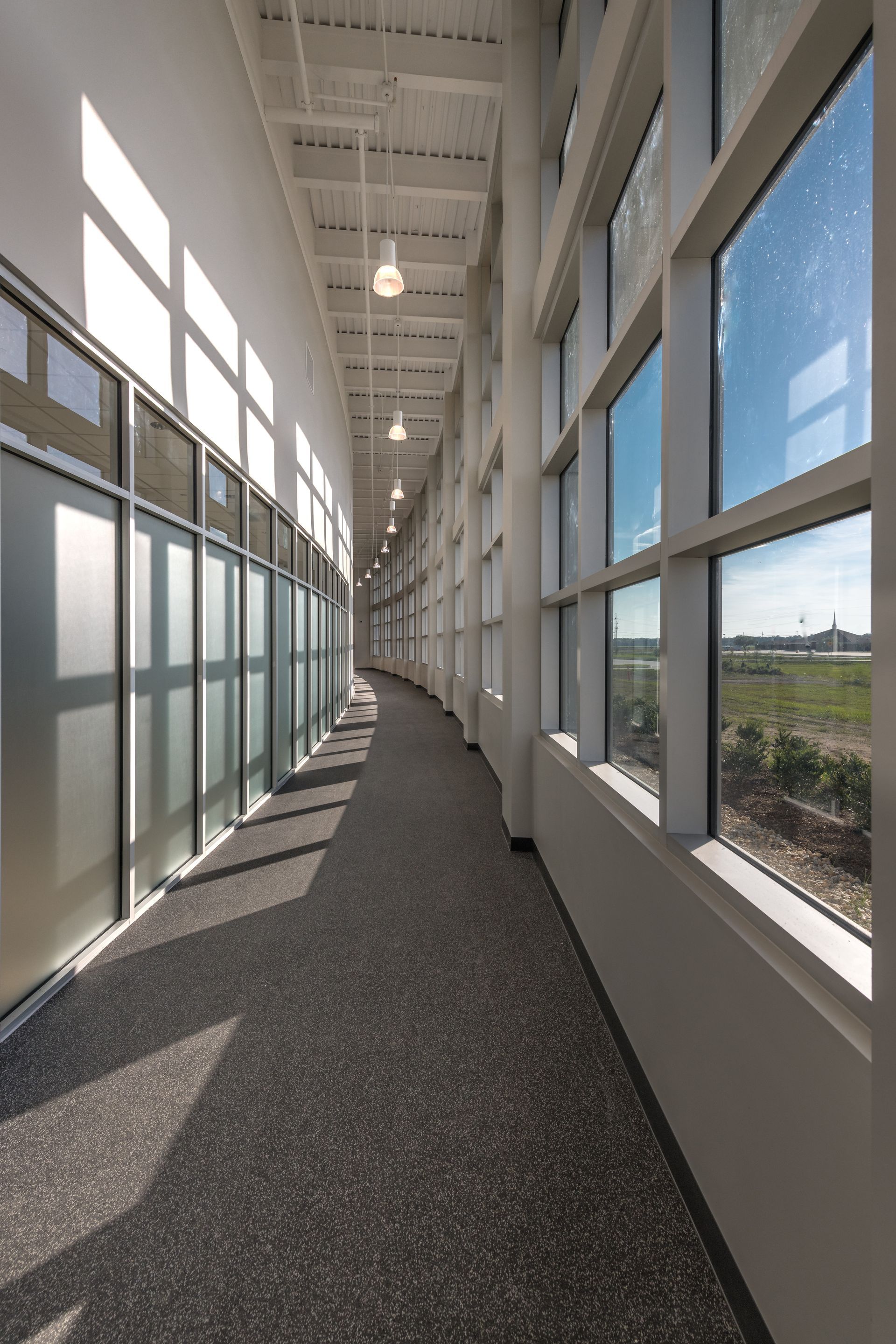 A long hallway in a building with lots of windows
