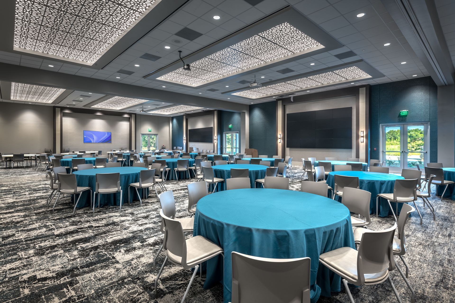 A large room with tables and chairs set up for a conference.