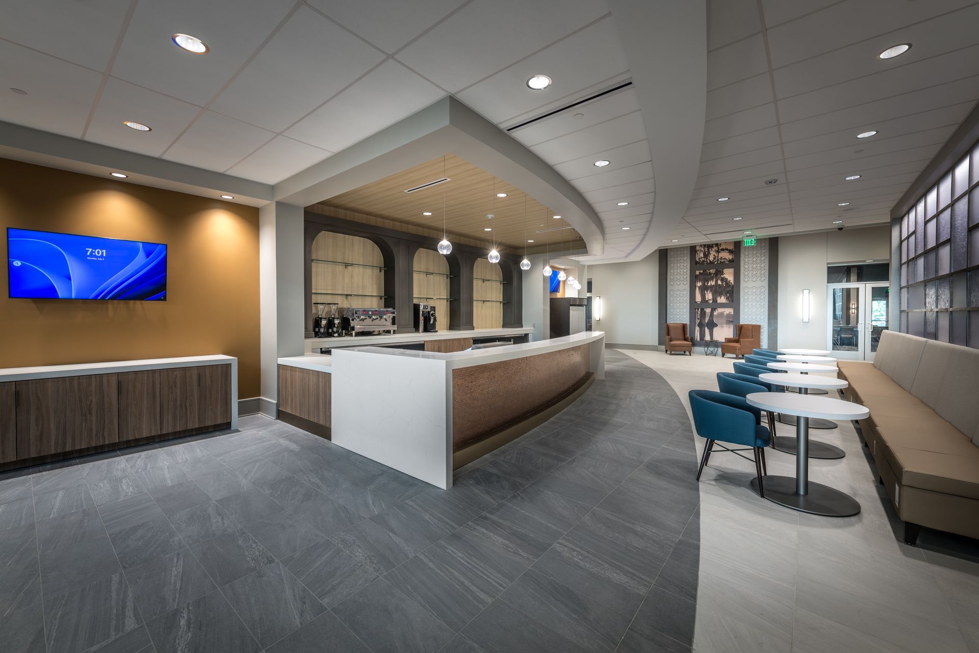 A large room with tables and chairs and a counter.