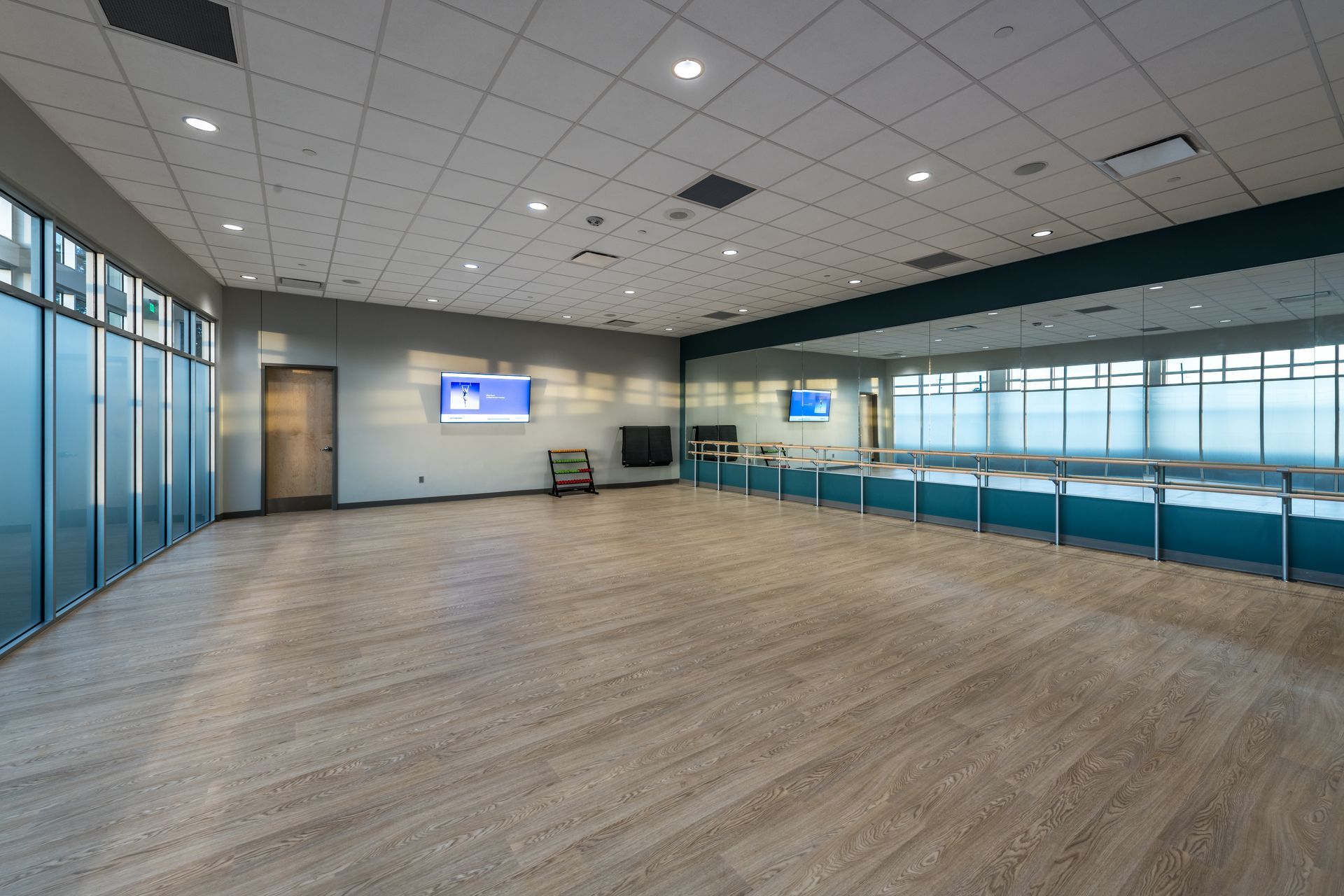 An empty dance studio with a large mirror on the wall.