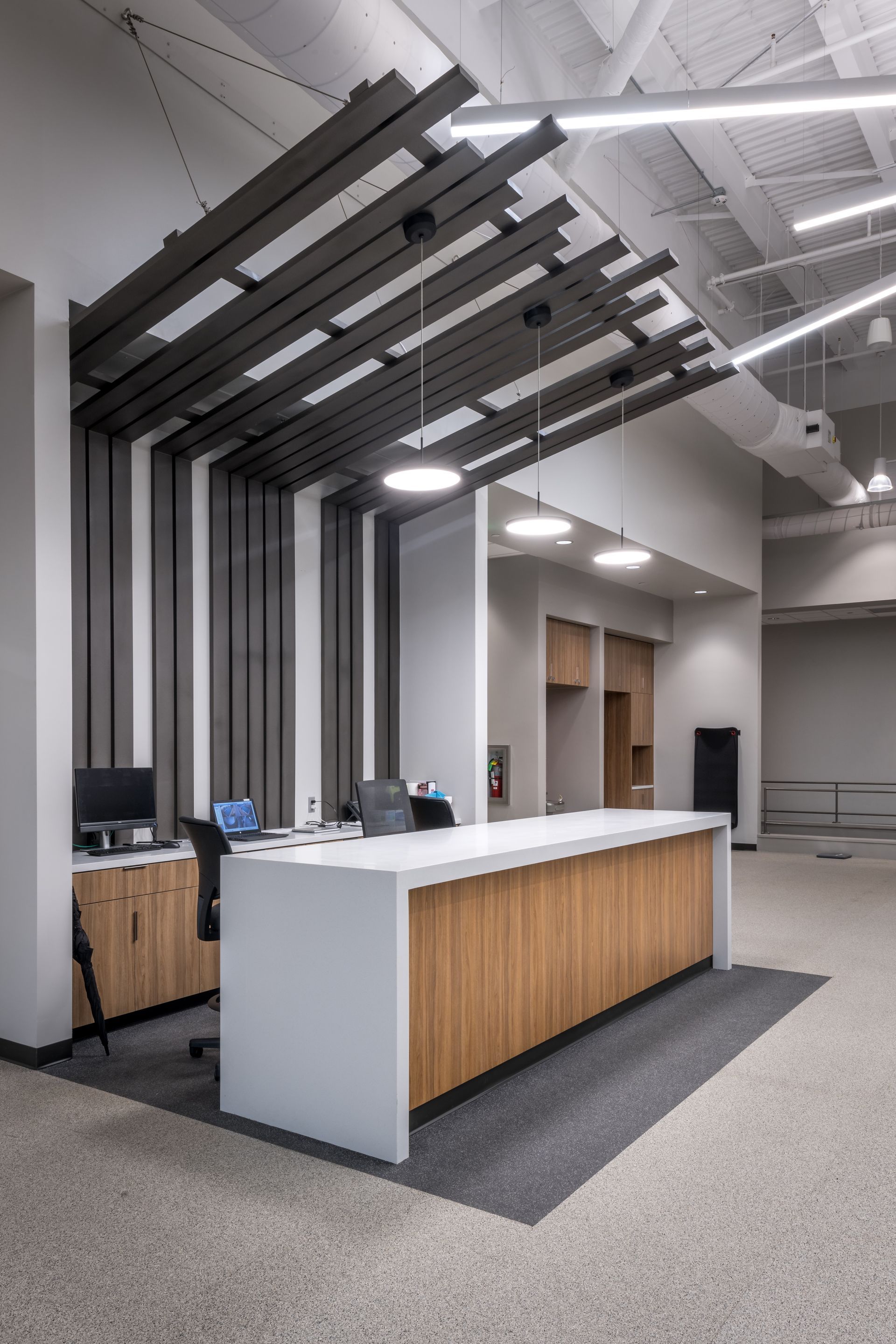 A reception desk in a large room with a wooden counter top.