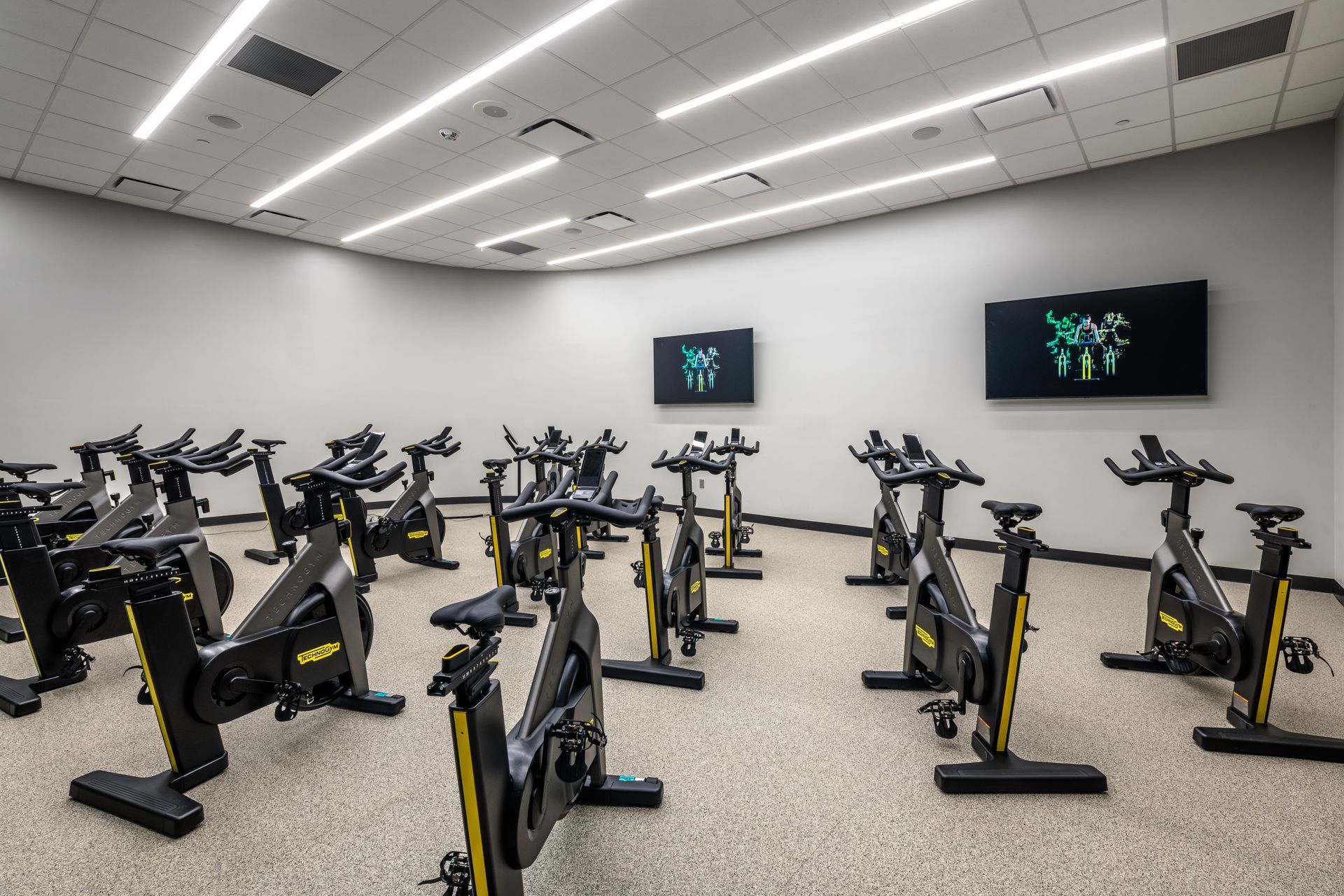 A gym with a lot of exercise bikes in it