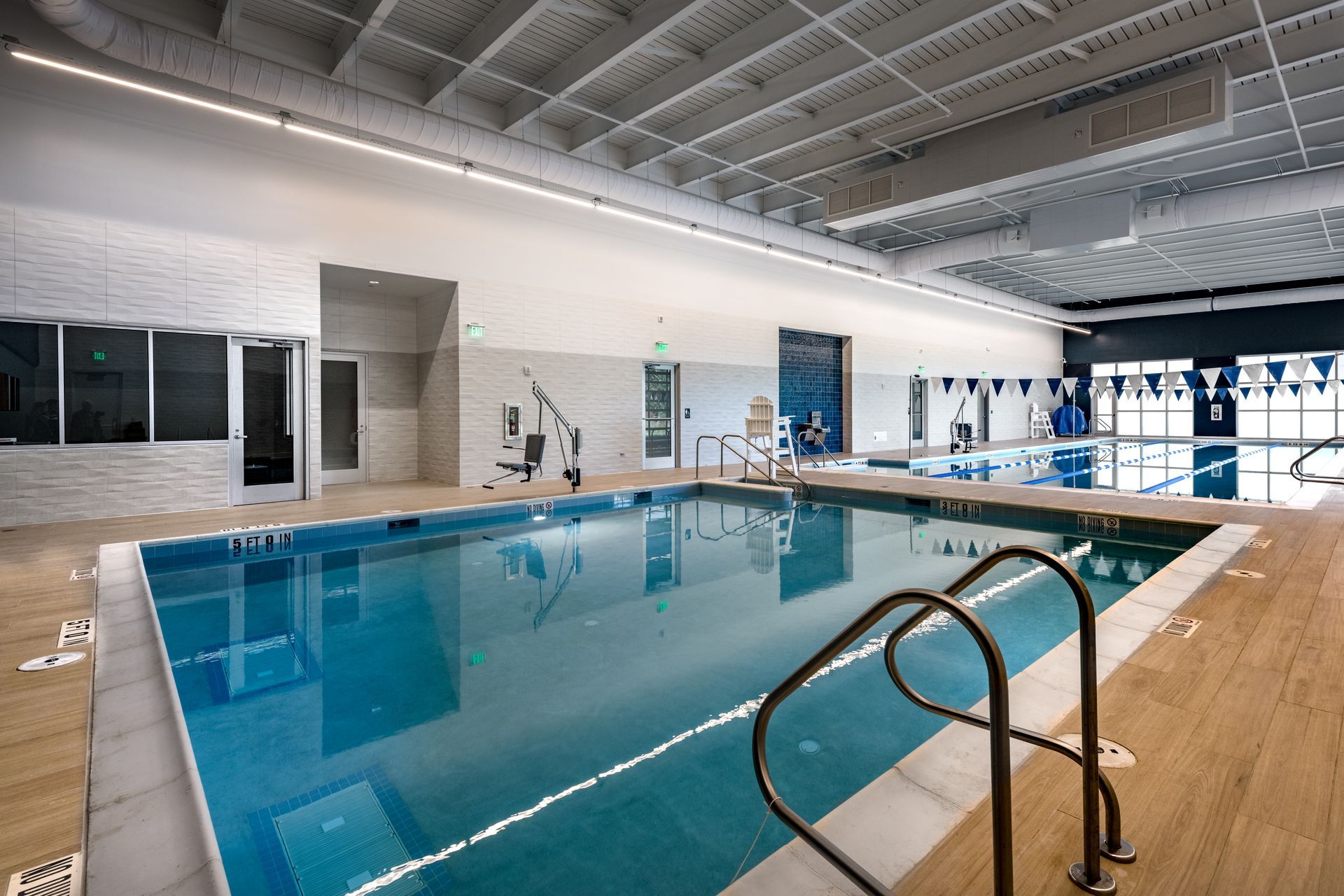 A large indoor swimming pool with stairs leading to it