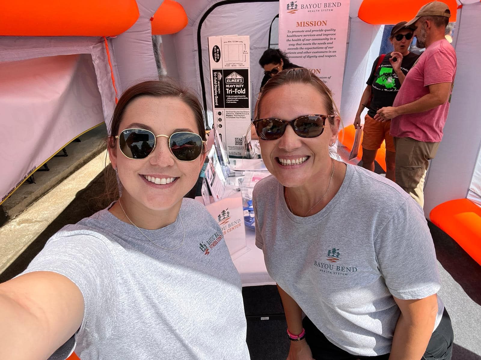 Two women wearing sunglasses are posing for a selfie.