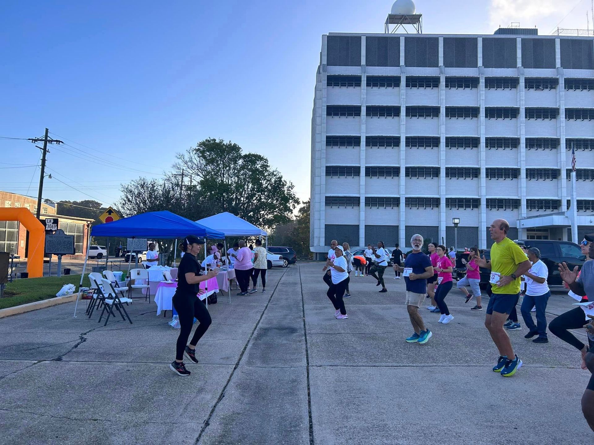 A group of people are dancing in front of a building.