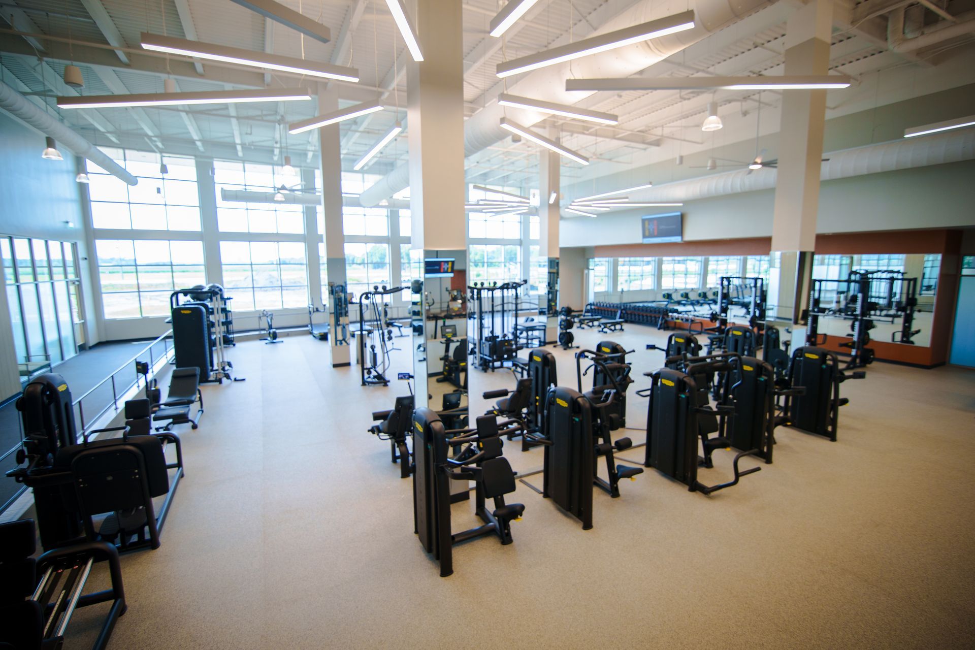 A large gym filled with lots of exercise equipment.