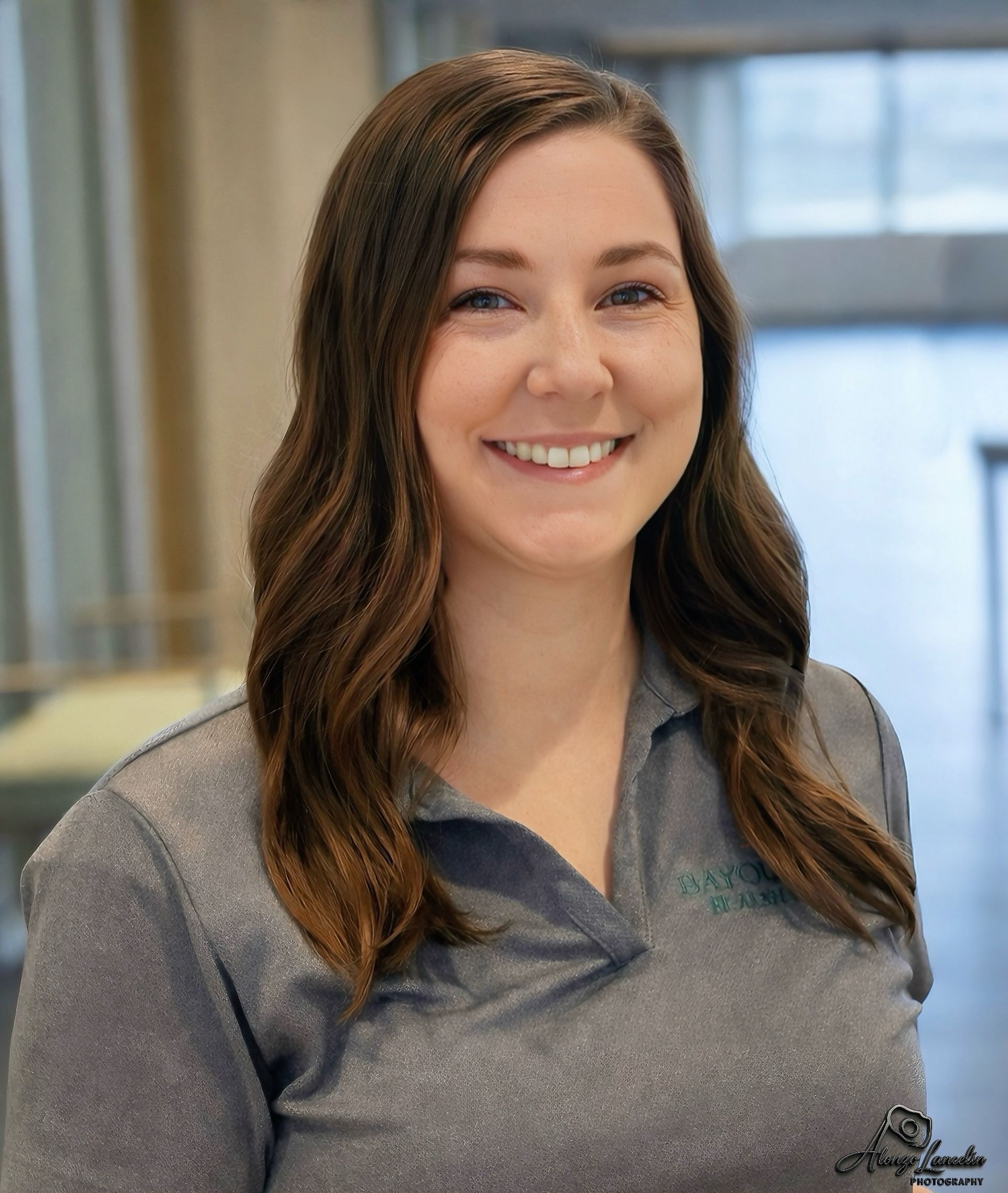 A woman is sitting in a chair in front of a window.