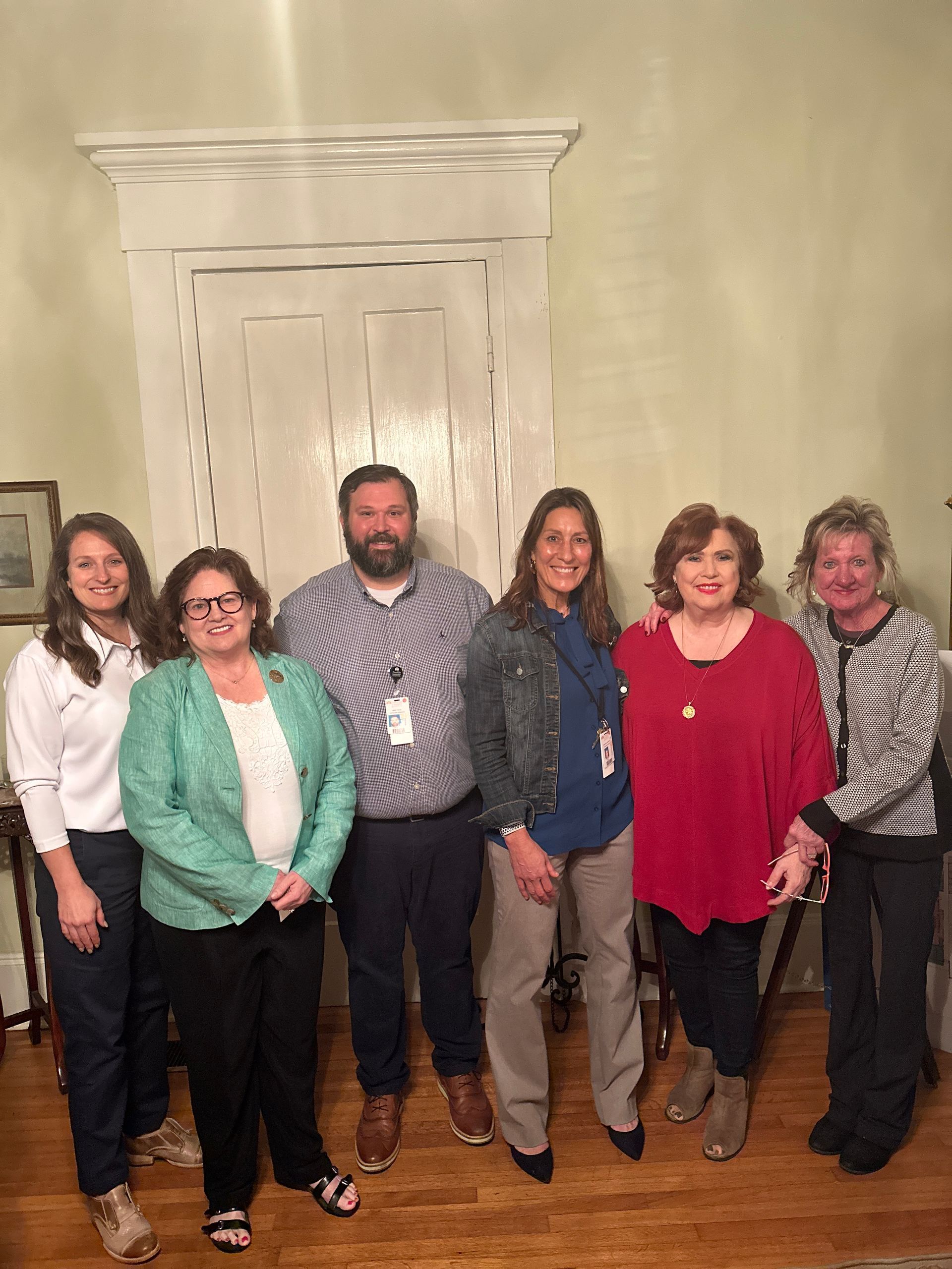 A group of people are posing for a picture in a room.